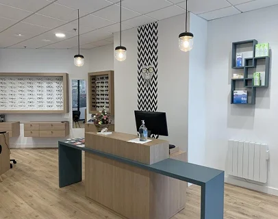 Intérieur d'un opticien moderne avec présentoirs à lunettes, comptoir de réception et étagères murales à Loire-Authion et à Mazé-Millon près d'Angers dans le Maine-et-Loire 49
